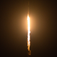 A photo of a space rocket launching at night.
